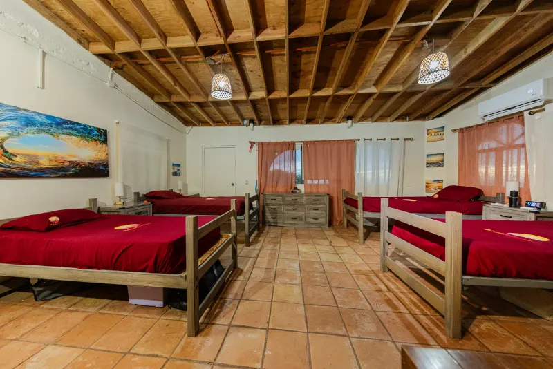 Shared Baja Rehab bedroom with single beds, bedside drawers and exposed wooden beams