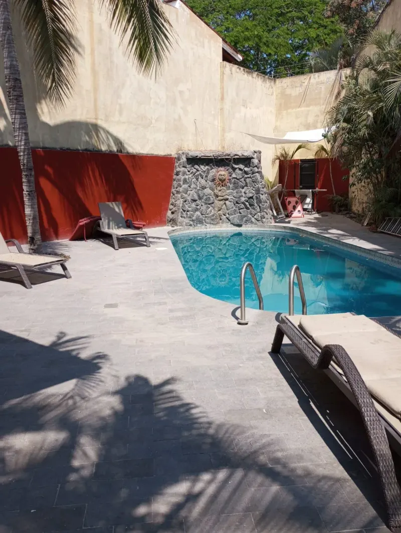 Pool courtyard with loungers and red boundary walls