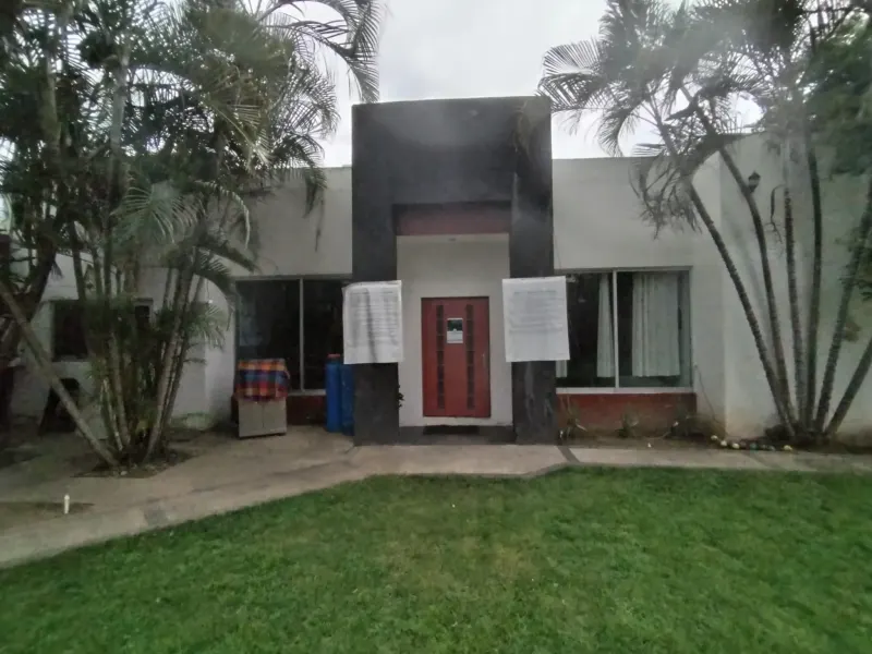Residence exterior with a red door, large windows and palms