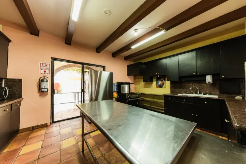 Baja Rehab kitchen with dark cabinets, a refrigerator and a central preparation table