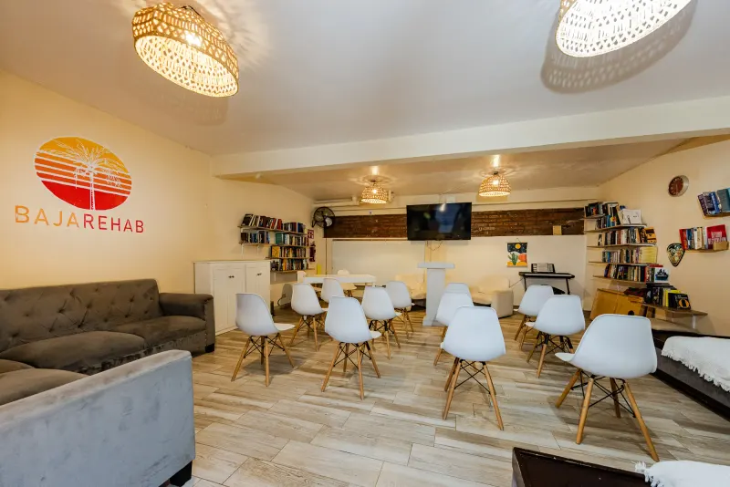 Baja Rehab group room with white chairs, bookshelves and a sofa