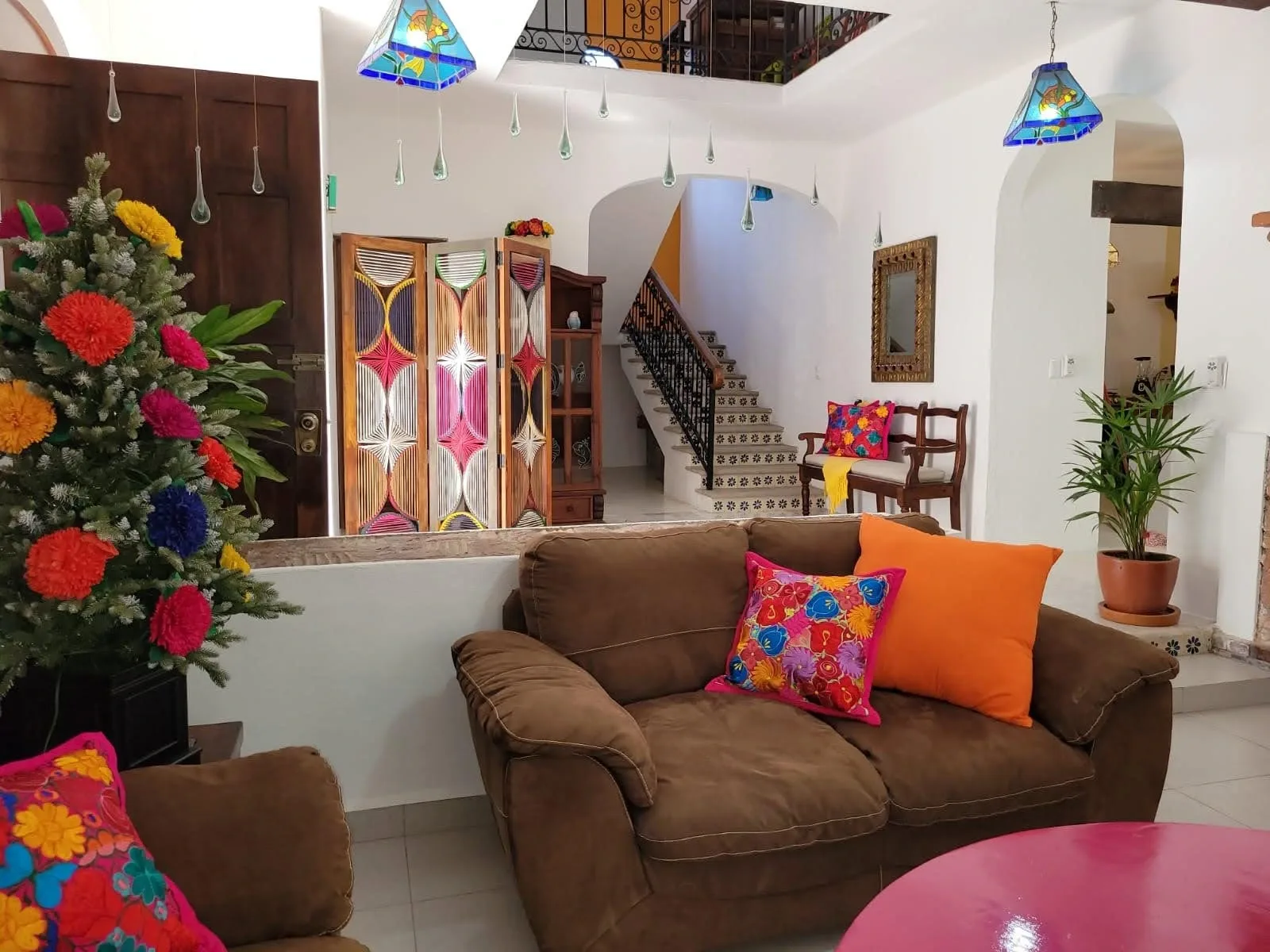 Living room beside a tiled staircase and colorful cabinet doors