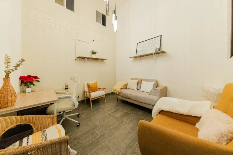 Furnished room at Baja Rehab with a desk, sofa and armchairs