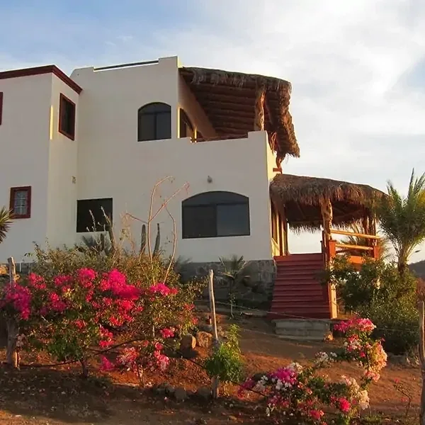 Las Olas residence facade with stairs, flowering garden and palapa balconies