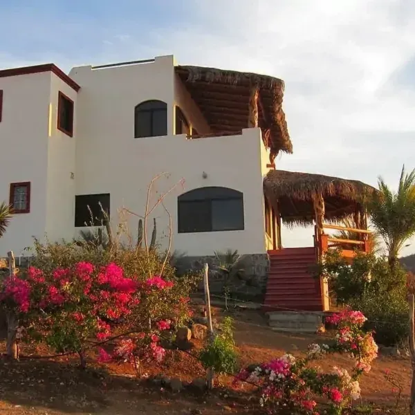 Las Olas residence facade with stairs, flowering garden and palapa balconies