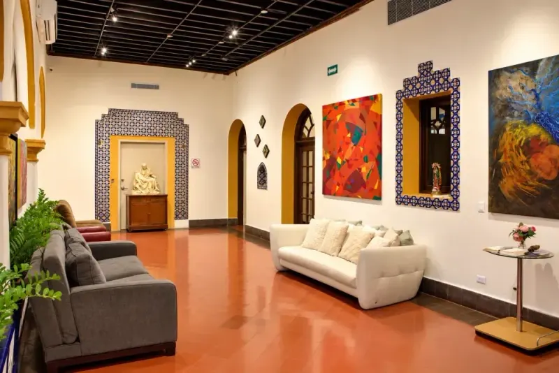 Main hallway with a white sofa, tilework and paintings