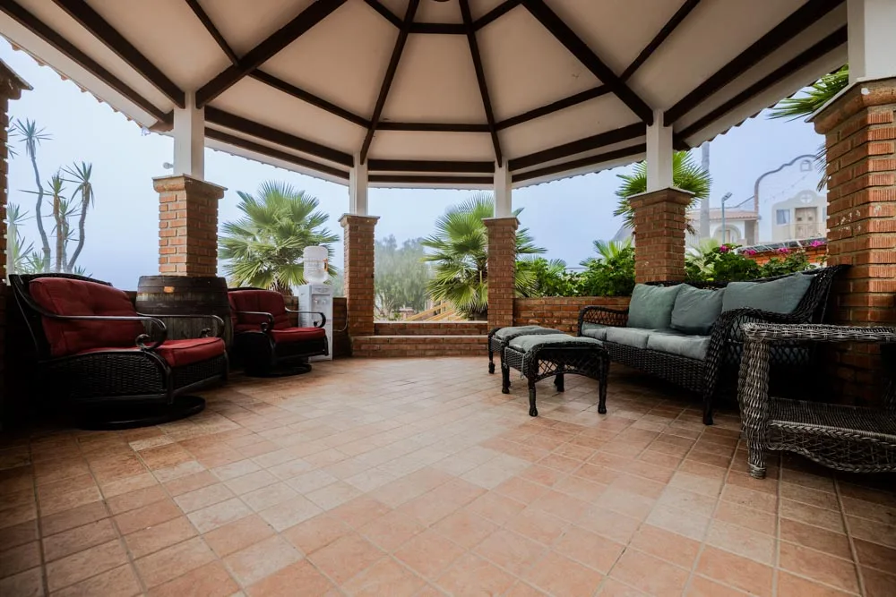 Covered Baja Rehab terrace with sofas, armchairs and views of the grounds