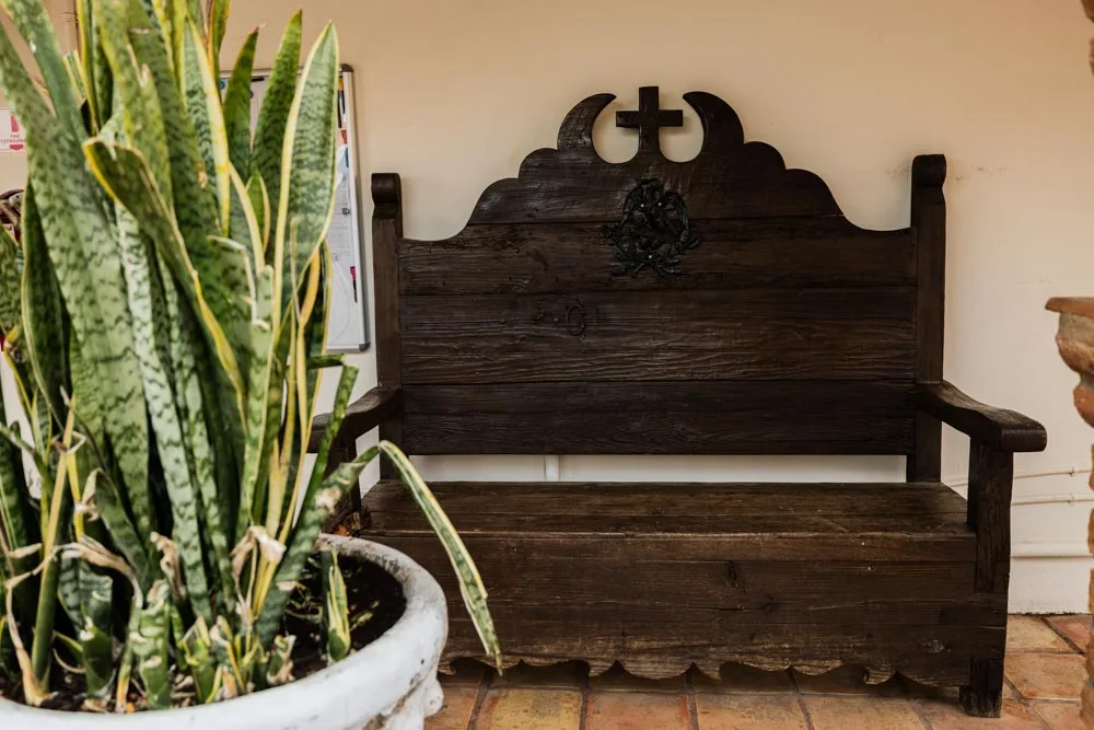 Wooden courtyard bench and potted plants at Baja Rehab