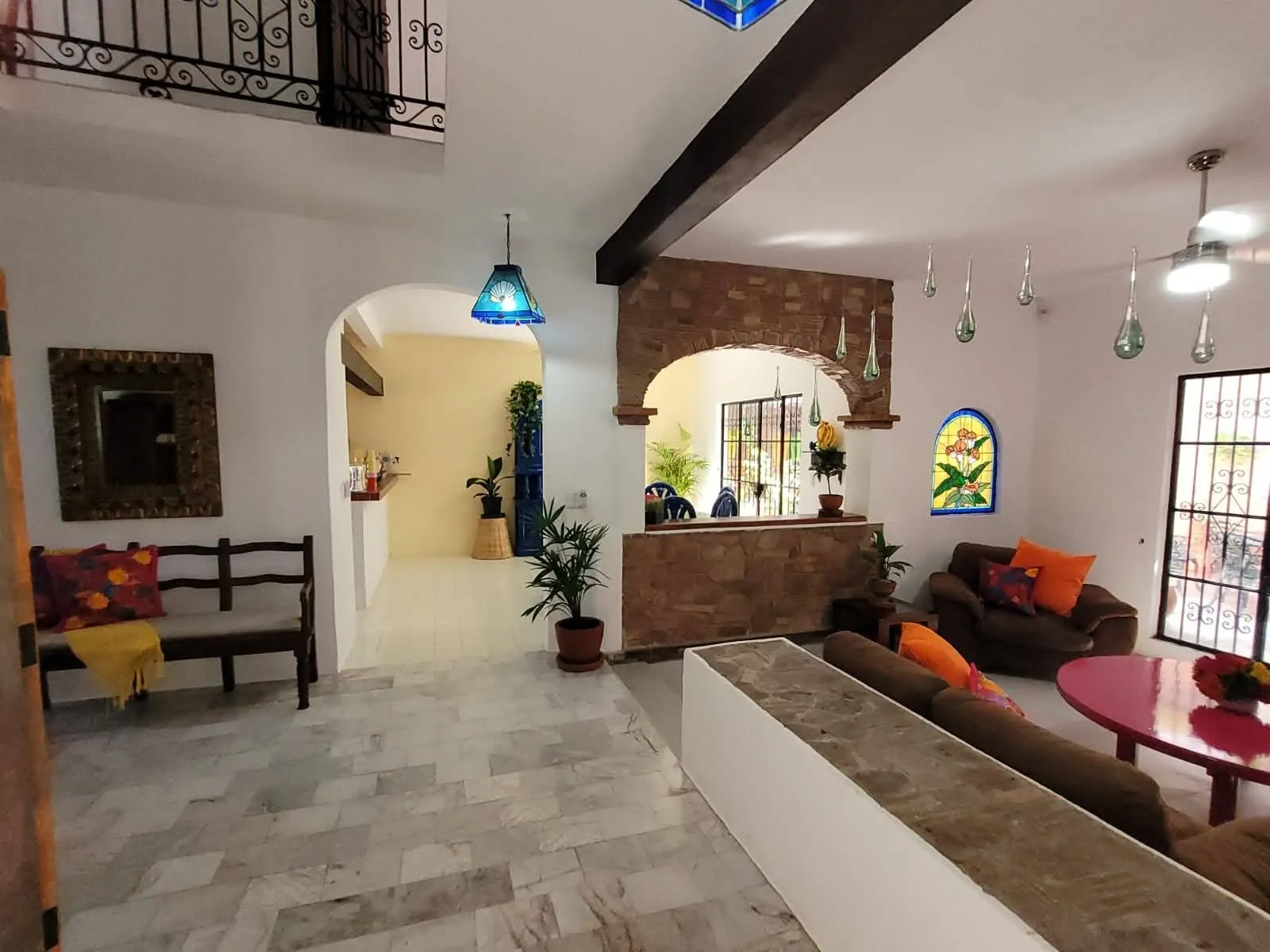 Entrance and living area with arched doorways, a built-in bench and tiled floor