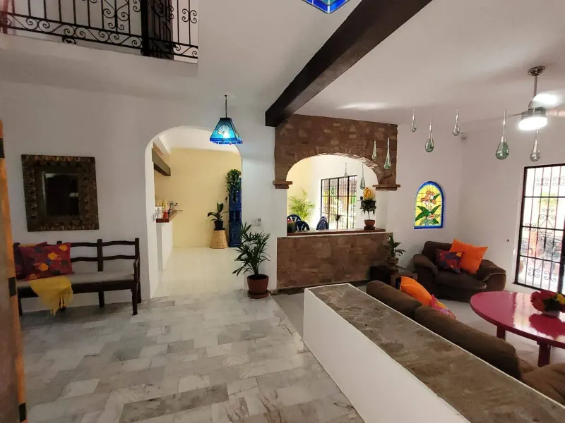 Entrance and living area with arched doorways, a built-in bench and tiled floor