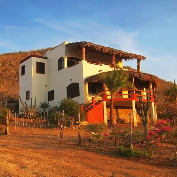 Two-story Las Olas residence with palapa balconies and a garden