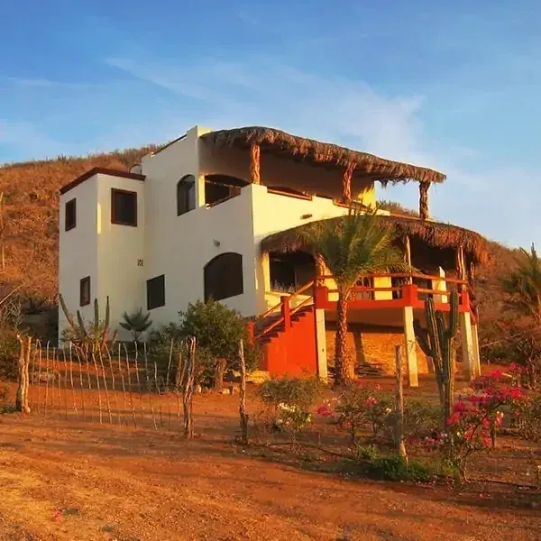 Two-story Las Olas residence with palapa balconies and a garden