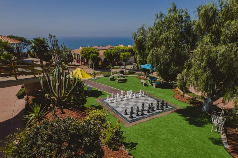 Large outdoor chessboard, garden seating and coastal view at Baja Rehab
