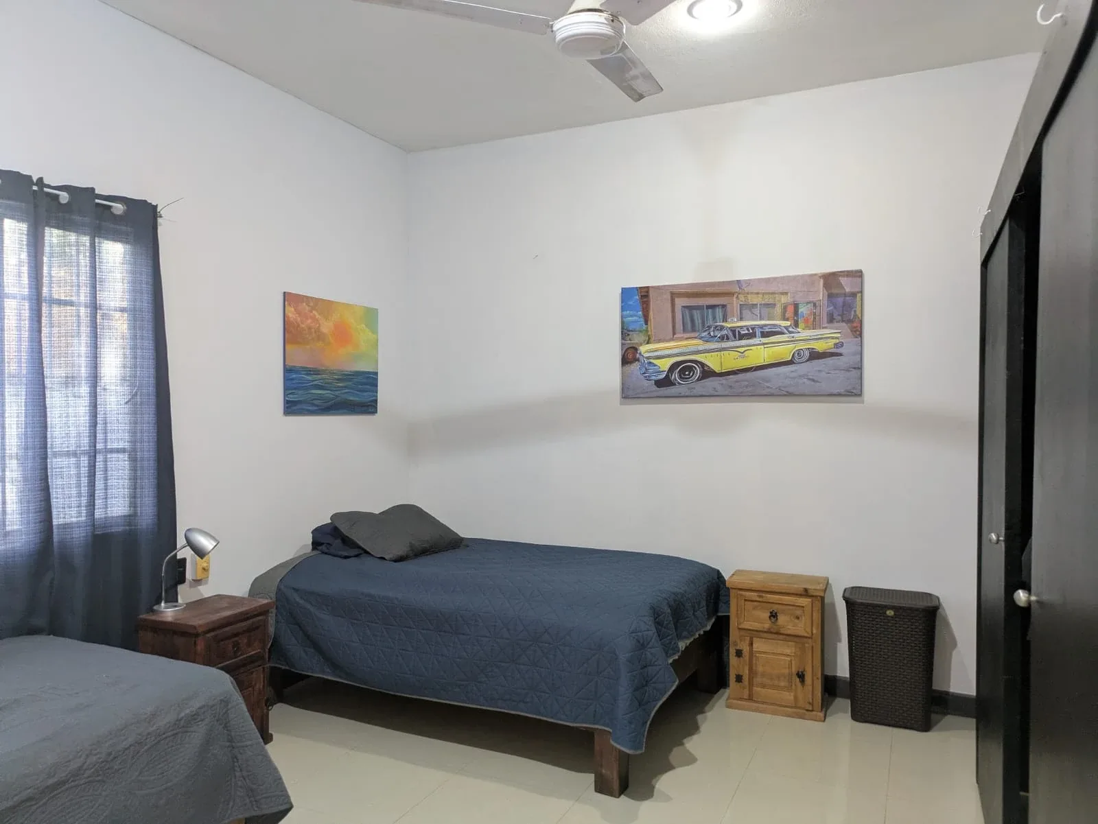 Bedroom with dark bedding, bedside tables and wall art