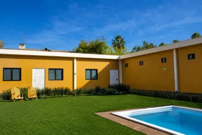 Lumenia’s garden and pool surrounded by the yellow house